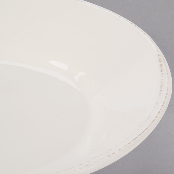 A Libbey round cream porcelain bowl with a rim.