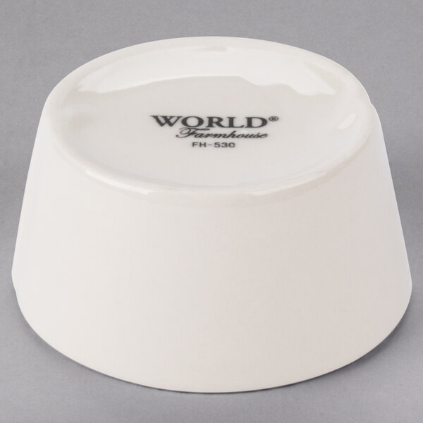 A white Libbey porcelain sauce bowl with black text that says "World" on it.