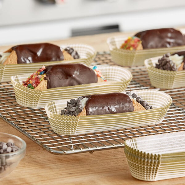 A tray of pastries in gold oval baking cups on a rack.