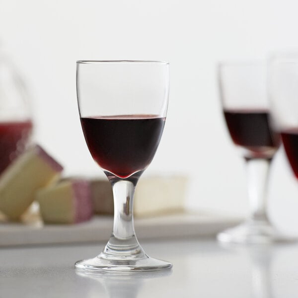 A Libbey Embassy sherry glass filled with red wine on a white background.