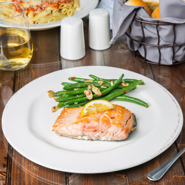 A Libbey Farmhouse porcelain plate with salmon, green beans, and pasta on a table.