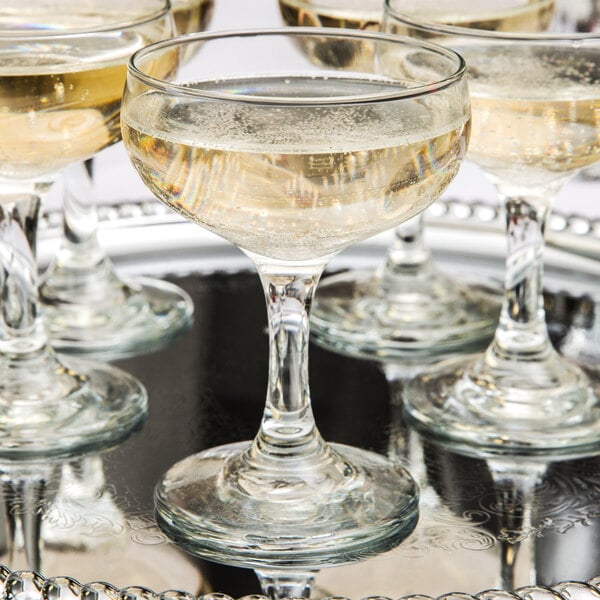 A close-up of a couple of Libbey Embassy Coupe Glasses filled with champagne.