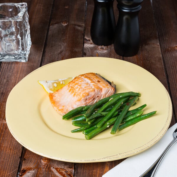 A Libbey Farmhouse butter yellow porcelain plate with salmon and green beans on a table.