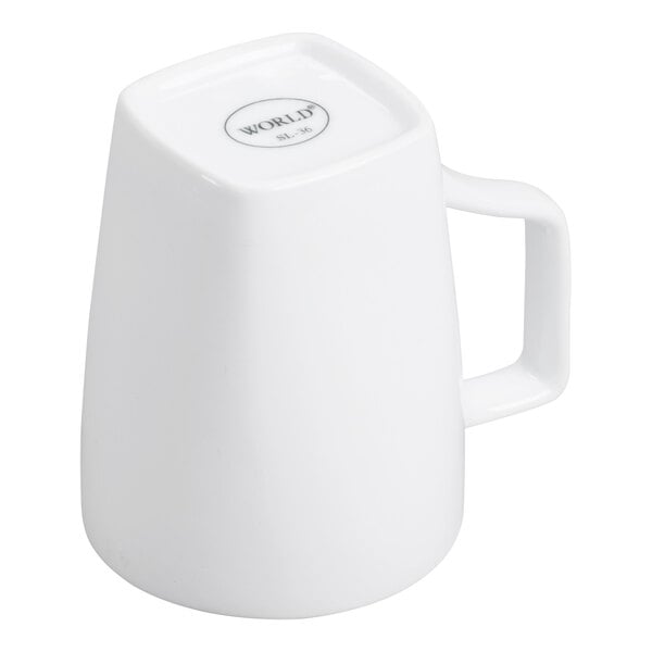 A white porcelain mug with a square handle, shown upside down.