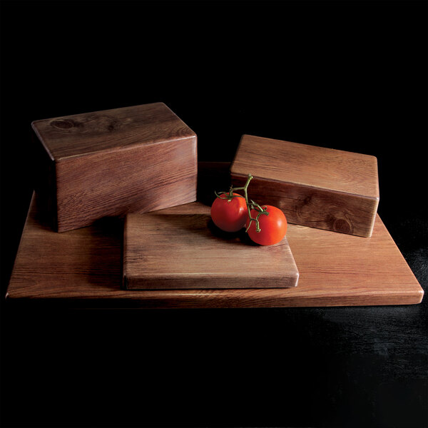 A rectangular faux walnut melamine modular riser with tomatoes on top.