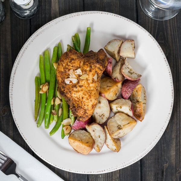 A Libbey Farmhouse porcelain plate with chicken, potatoes, and green beans on it.