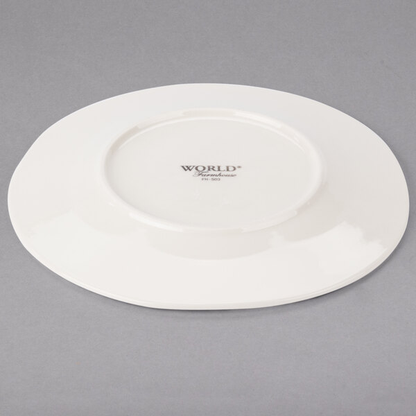 A Libbey round cream porcelain plate with a wide rim on a white background.