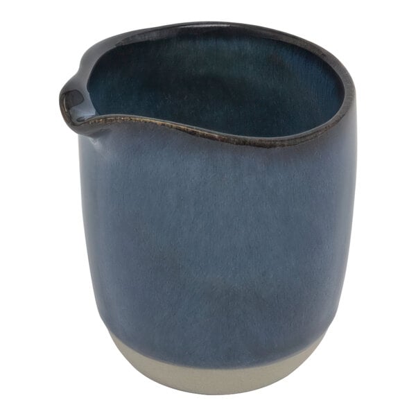 An indigo blue ceramic pitcher with a white rim and handle.