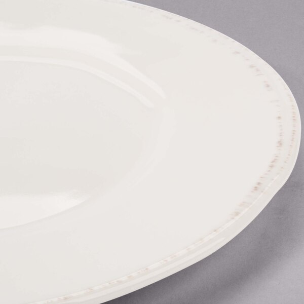 A Libbey round cream porcelain plate with a wide rim.