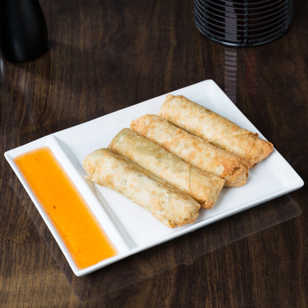 A Libbey Ultra Bright White porcelain cocktail plate with fried spring rolls in two compartments.