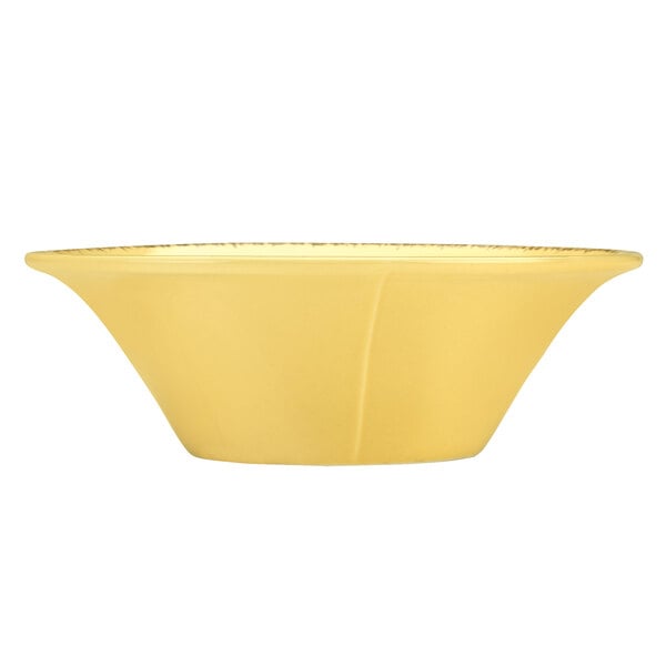 A Libbey round porcelain soup bowl with a yellow surface and gold border.