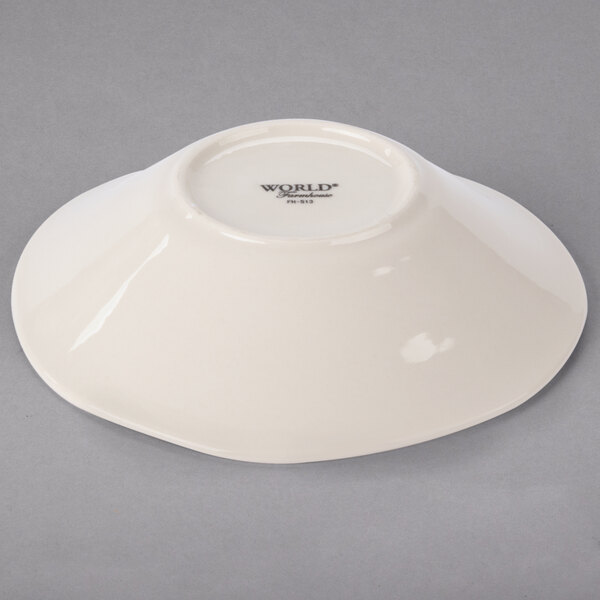 A Libbey round cream porcelain bowl on a gray surface.