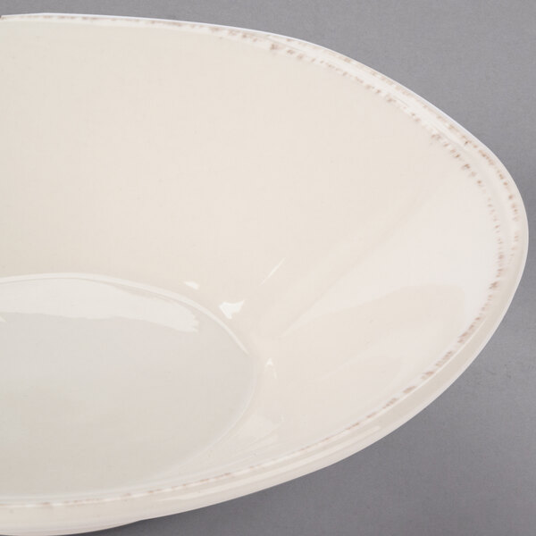 A Libbey round white porcelain bowl with a rim on a gray surface.