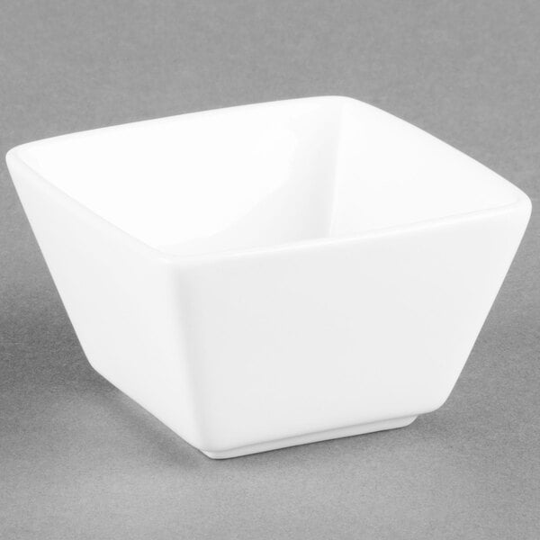 A Libbey Ultra Bright White Square Porcelain Bouillon Bowl on a gray background.