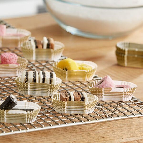A rack of small desserts in Novacart gold oval baking cups.
