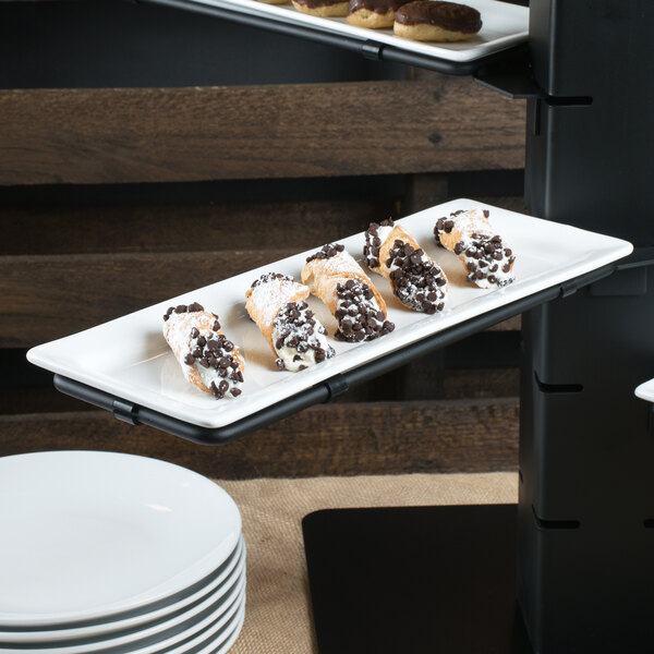 A Libbey Ultra Bright White rectangular porcelain plate with donuts and cookies on a table.