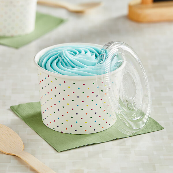 A Choice paper cup with a blue polka dot design and a plastic lid on a counter.