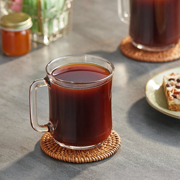 A glass mug of Maxwell House Original Roast coffee on a table.