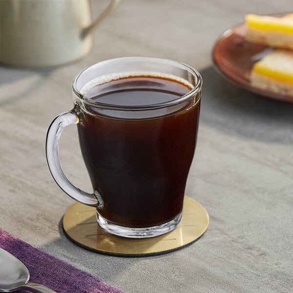 A glass cup of Maxwell House decaf coffee on a table.