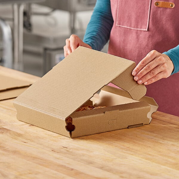 A woman opening a Choice Kraft corrugated pizza box.