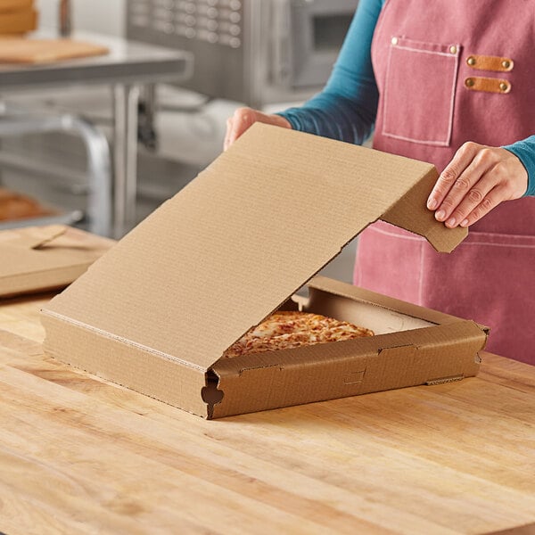 A woman opening a Choice Kraft pizza box on a table.