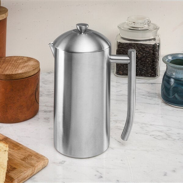 A stainless steel Frieling French press on a marble counter.