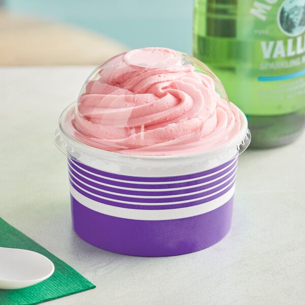 A purple Choice paper cup with a dome lid filled with pink frozen yogurt.