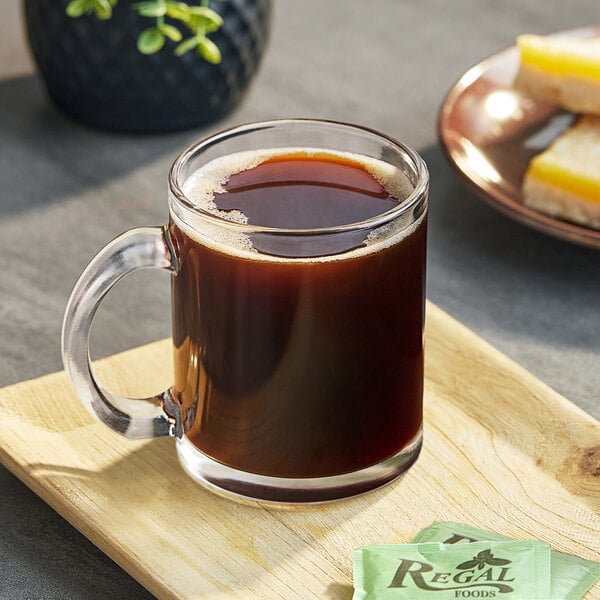 A wooden tray with a glass mug of Maxwell House Special Delivery coffee.