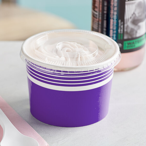 A close-up of a Choice purple paper frozen yogurt cup with a flat lid.