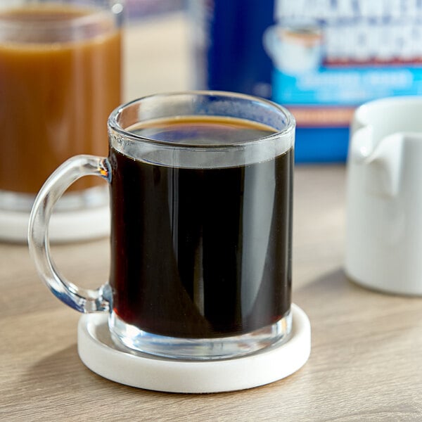 Maxwell House Original Roast Ground Coffee in a glass mug on a table.