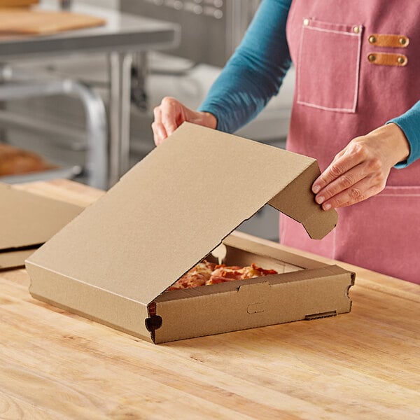 A woman opening a Choice Kraft corrugated pizza box.