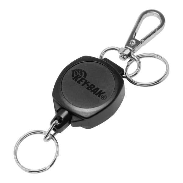 A close-up of a black KEY-BAK Snapback key chain with two black rings.