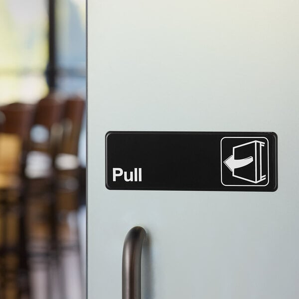 A black and white sign that says "Pull" on a white door.