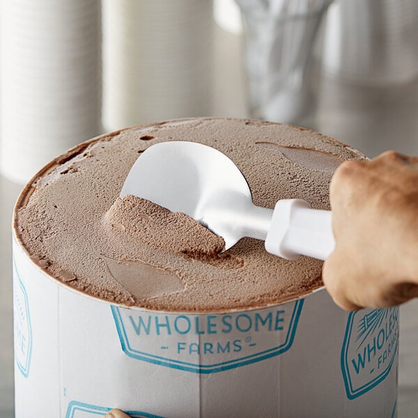 A hand using a Choice stainless steel ice cream spade to scoop ice cream.