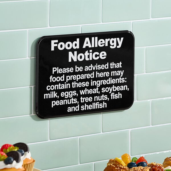 A black and white Lavex Food Allergy Notice sign on a wall.