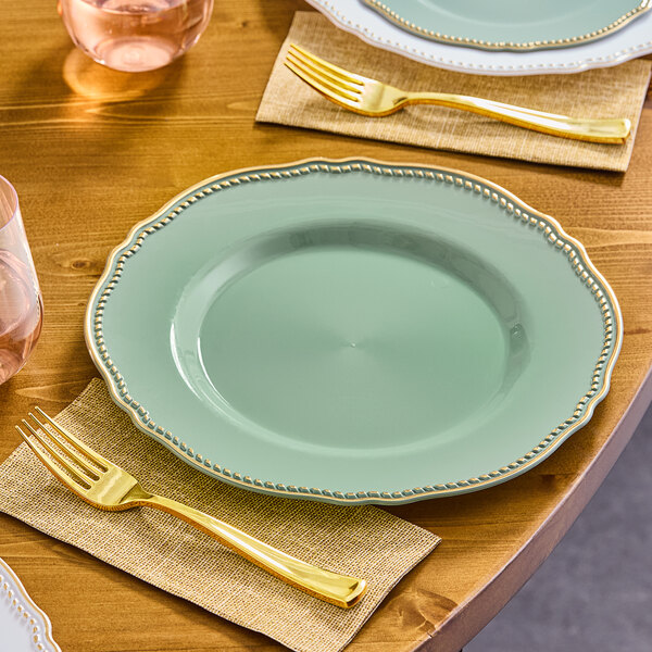 A Visions eucalyptus plastic plate with a gold vintage rim and a gold fork on a table.