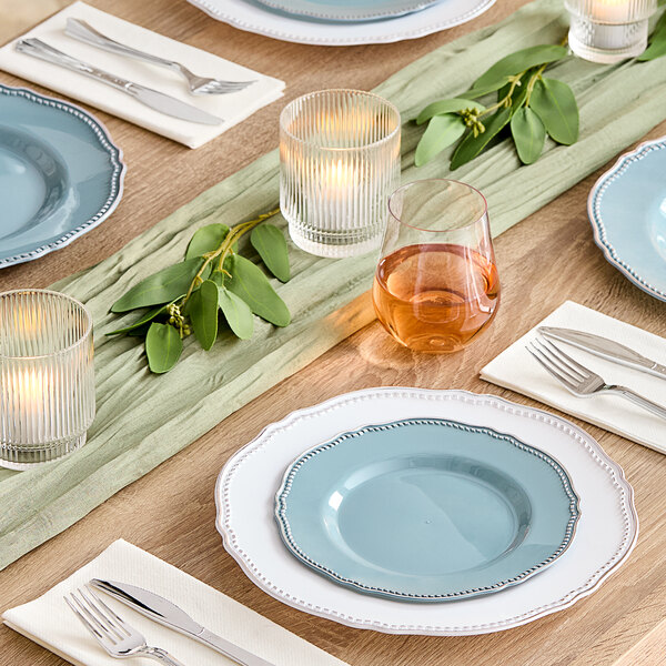 Visions Steel Blue plastic plates with silver vintage rims on a table with candles and plates.
