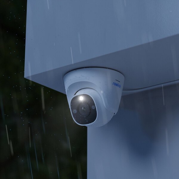 A Reolink dome security camera installed on a wall with a spotlight on a white background.