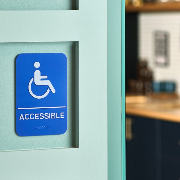 A blue and white Lavex plastic sign with the word "accessible" and a person in a wheelchair.