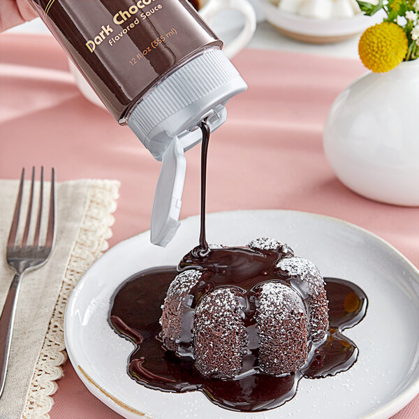 Monin Dark Chocolate sauce being poured on a chocolate dessert.