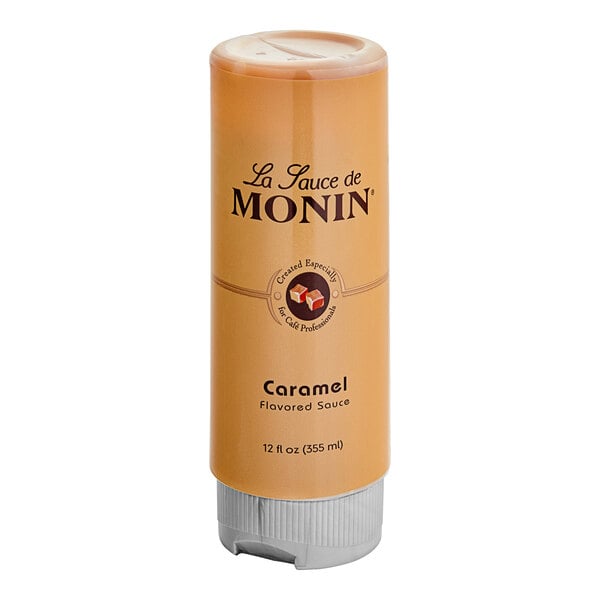 A Monin Caramel Flavoring Sauce bottle on a counter.