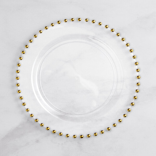 A clear plastic plate with gold beaded rims.