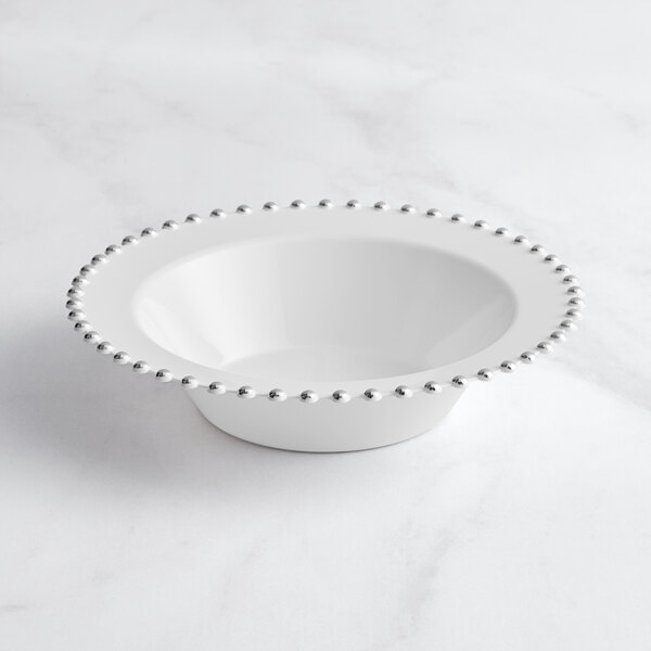 A white Visions plastic bowl with silver beaded rim.