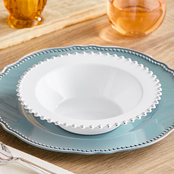A white bowl with silver beaded trim.