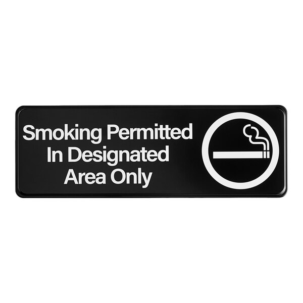 A black sign with white text that says "Smoking Permitted In Designated Areas Only"