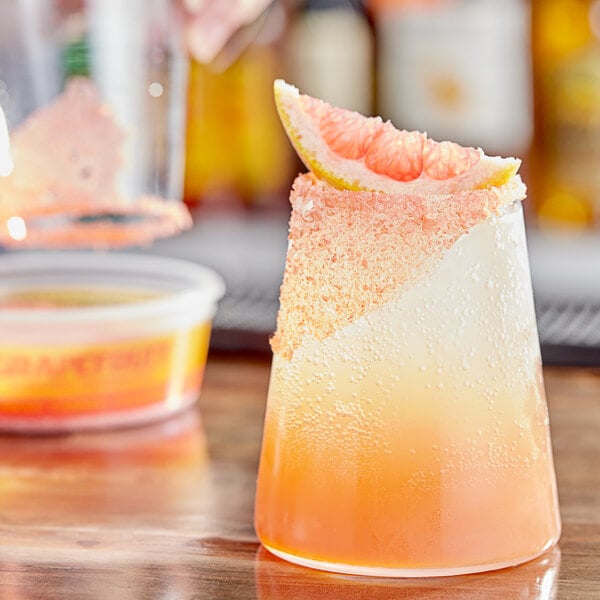 A glass with a drink rimmed with Twang Grapefruit Rimming Salt.