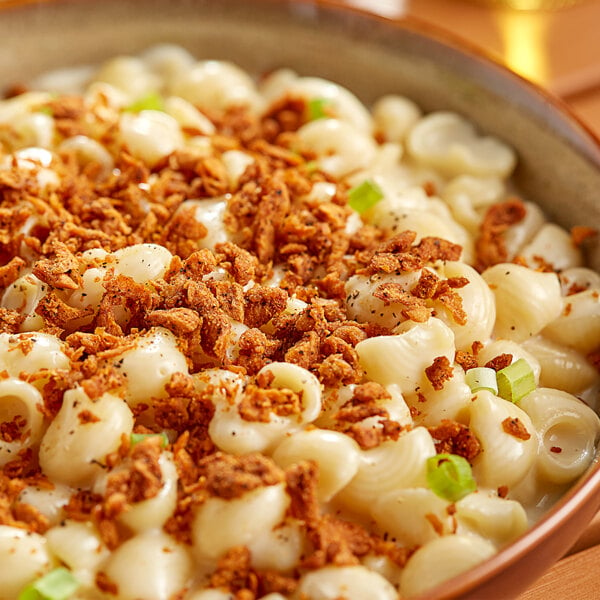 A bowl of macaroni and cheese topped with Barvecue Plant-Based Vegan Wood-Smoked Crumbled Bacon.