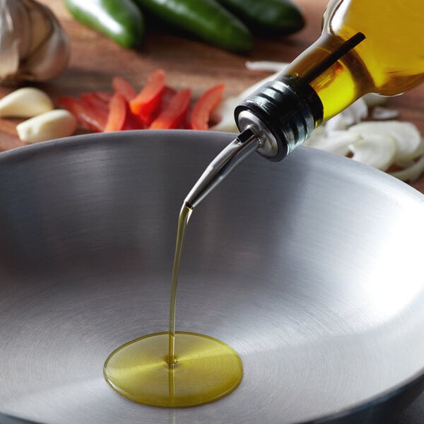 A person pouring Del Destino Olive Pomace Oil into a pan.