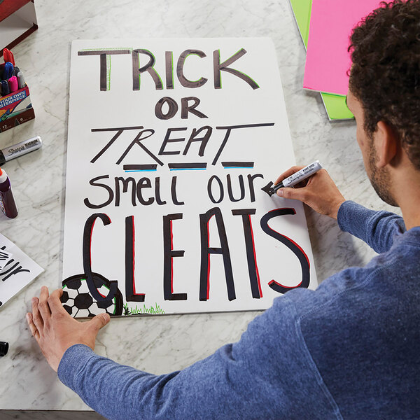 A man writing on a sign with a Sharpie Magnum Black XL Chisel Tip Marker.