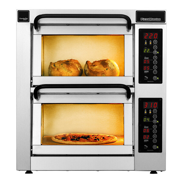 Two PizzaMaster electric countertop pizza ovens with pizzas cooking inside.